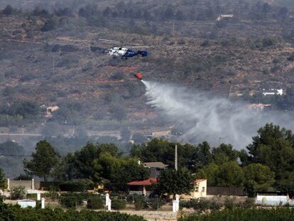 Un helicóptero descarga agua en Pedralba.