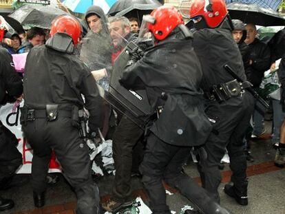 Agentes de la Ertzaintza forcejean con los manifestantes.