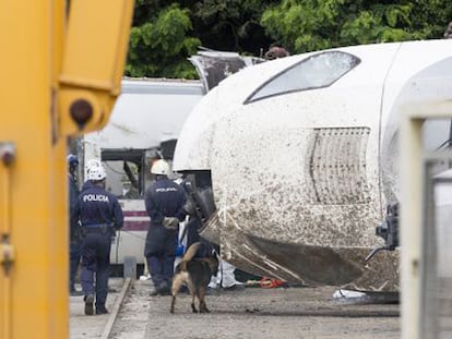 Policías rastrean los vagones del tren siniestrado.