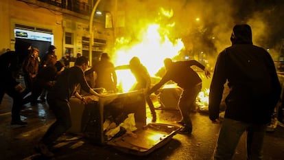 Encapuchados queman un contenedor en el barrio de Sants.