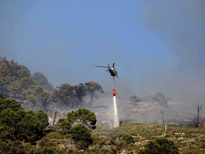 Un helicóptero actúa contra el fuego en Cómpeta.