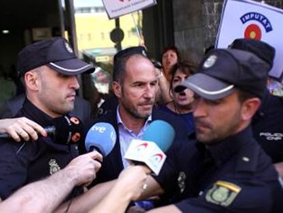 El periodista Lluís Motes, escoltado por la policía.