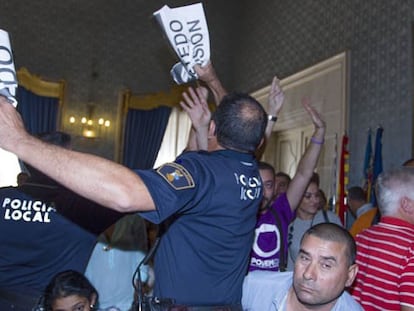 La Policía Local de Alicante requisa carteles de "Castedo Dimisión" en el pleno municipal.