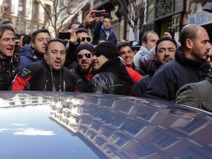 Javier Barbero sale del bar mientras le increpan los policías. EFE