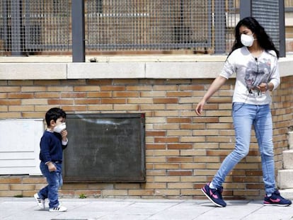 Una madre y su hijo caminan este martes con mascarillas por El Quiñón, en Seseña.