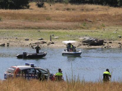 Un grupo especial de buzos de la Guardia Civil trabajan para llegar hasta el helicóptero que se ha estrellado en el pantano de Valmayor.