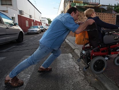 Mayte Corbacho es ayudada por un vecino en una calle del barrio de Entrevías.