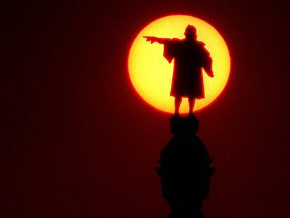 La escultura de Colón del monumento barcelonés rodeado del sol. FOTO: AGUSTÍ CARBONELLE. VÍDEO: EL PAÍS VÍDEO