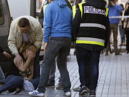 Puerta del local de Alcorcón en el que un hombre disparó a bocajarro al camarero y a una mujer. En la foto, la cuñada del fallecido.