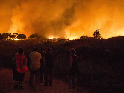 Amparanoia se topa con el fuego en la carretera. En la foto, vecinos de Devesa (Vilardevós) observan el incendio forestal declarado ayer.