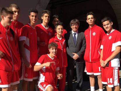 Carles Puigdemont se fotografía con los jugadores de baloncesto en Barcelona.