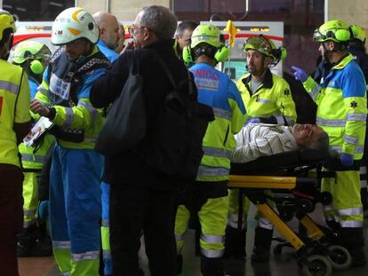 Efectivos médicos trasladan a un herido tras un accidente de un tren de cercanías en la Estación de Alcalá de Henares.