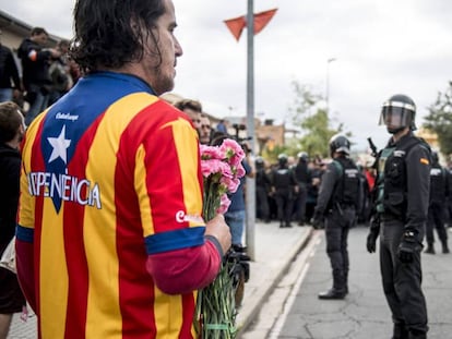 Un manifestante independentista recibe con flores a la Guardia Civil en Sant Julia de Ramis (Girona) el 1 de octubre.