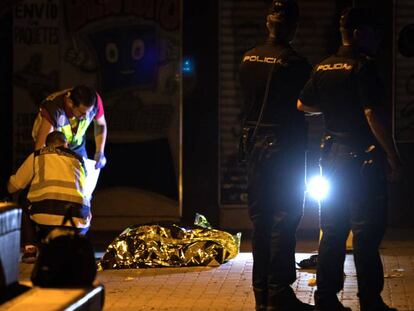 Agentes de la policía nacional junto al cuerpo del joven asesinado.