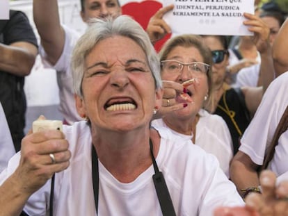 Una afectada por el cierre de las clínicas iDental muestra el estado de su boca durante la concentración de este miércoles / En vídeo, los afectados de Idental, en Madrid, recibirán en septiembre sus historias clínicas