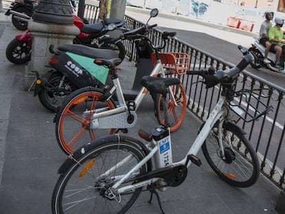 Bicicletas y motos de varias empresas de alquiler, ayer, en una calle del centro de Madrid.