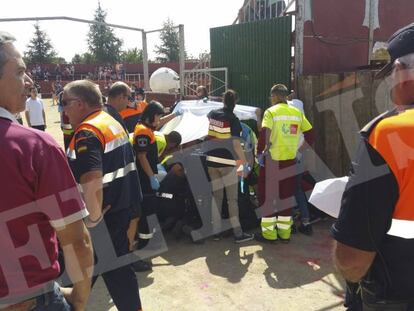 Sanitarios y voluntarios de Protección Civil atienden al herido, con la bola al fondo.