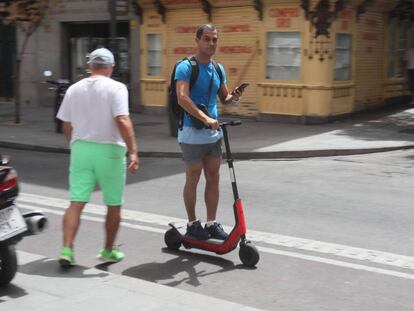Un hombre circula con un patinete eléctrico por un carril bici del centro de Madrid.