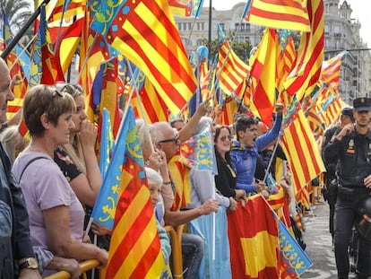 Manifestantes ondean banderas de la Senyera en la plaza del Ayuntamiento en Valencia.