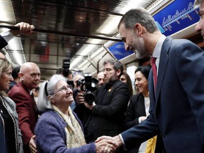 El rey Felipe saluda a una mujer durante el recorrido en metro entre las estaciones de Sol y Chamartín, en el acto conmemorativo del centenario de la puesta en funcionamiento de la primera línea de Metro de Madrid.