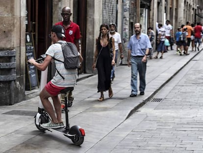 Un hombre con un patinete en Barcelona. En vídeo, la importancia de los frenos en los patinetes.