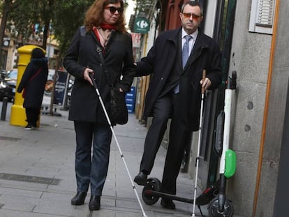 Dos personas ciegas sortean un patinete eléctrico en el centro de Madrid. En el vídeo, paseo con una persona ciega por la ciudad.