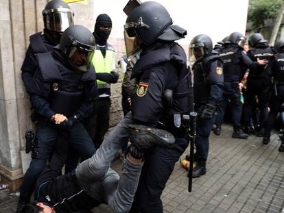 Agents de la Policia Nacional immobilitzen un home durant els incidents al col·legi Balmes de Barcelona l'1-O.