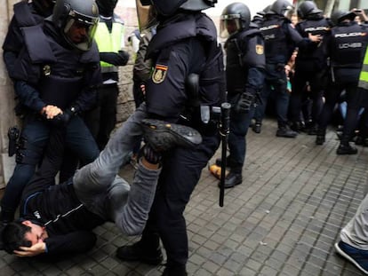 En foto, agentes de la Policía Nacional inmovilizan a un hombre durante los incidentes en el colegio Balmes de Barcelona, el 1 de octubre de 2017. En vídeo, 20-S: nace el relato de la violencia. Juicio al 'procés'.