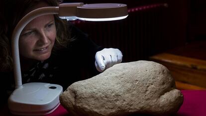 En vídeo, la investigadora Inés Domingo junto a la piedra paleolítica con la escena de grullas y humanos.