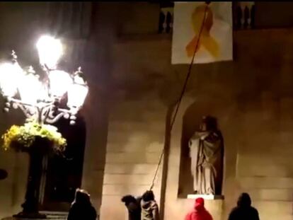 Momento de la retirada del lazo amarillo del Ayuntamiento de Barcelona. En vídeo, identificadas cinco personas por quitar el lazo amarillo del Ayuntamiento de Barcelona.