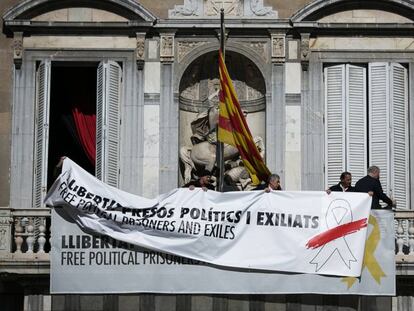 Trabajadores de la Generalitat colocan una pancarta con un lazo blanco encima de la que había antes. En vídeo, la Junta Electoral ordena a los Mossos que retiren los simbolos independentistas.