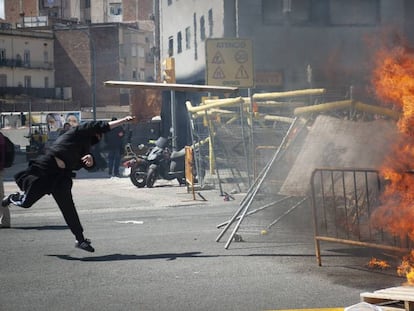 Un manifestante independentista tira piedras este sábado, en Barcelona. En vídeo, la concentración contra Vox acaba con incidentes.