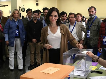 La candidata del PP a la presidencia de la Comunidad de Madrid, Isabel Díaz Ayuso, votando en el IES Lope de Vega en Madrid. En vídeo, el secretario general de Vox, Ortega Smith, promete "echar" a Carmena del Ayuntamiento.