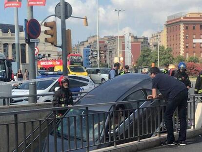 El coche, antes de ser retirado de la bajada al metro de Plaza España en Barcelona. En vídeo, los equipos de emergencias retirando el vehículo.