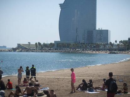 En foto, la playa de Sant Sebastià desalojada por la Guardia Urbana de Barcelona. En vídeo, los explosivos encontrados bajo el mar.