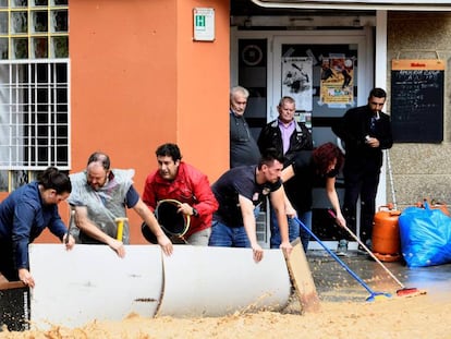 Varios vecinos intentan bloquear el paso del agua en Arganda del Rey (Madrid).