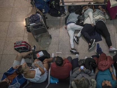 Pasajeros durmiendo en la terminal 1 del aeropuerto de Barcelona. En vídeo, así fueron los choques entre manifestantes y policía en El Prat.