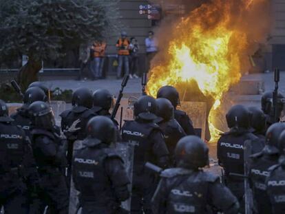 Antidisturbios de la Policia Nacional delante de un gran fuego en Via Laietana, en Barcelona. En vídeo, las consecuencias de la noche de disturbios en Cataluña.