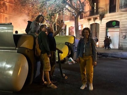 Varias personas se fotografían delante de unos contenedores, el jueves. En vídeo, así ha sido el séptimo día de protestas contra la sentencia del 'procés' en Barcelona.