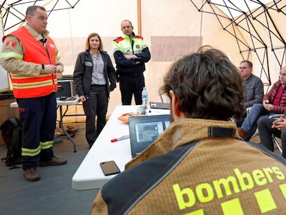 El 'conseller' Miquel Buch (sentado, primero por la derecha) y Albert Ventosa (primero por la izquierda), coordinador y responsable del dispositivo de bomberos, atienden a los medios. En vídeo, declaraciones del 'conseller'.