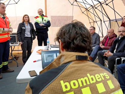 El 'conseller' Miquel Buch (sentado, primero por la derecha) y Albert Ventosa (primero por la izquierda), coordinador y responsable del dispositivo de bomberos, atienden a los medios. En vídeo, declaraciones del 'conseller'.