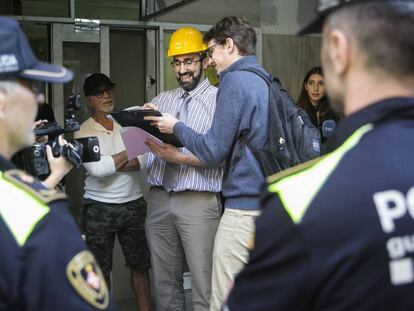 Los socios de Haibu 4.0, Eduardo Jausi (alias Eddie Wattenwil), con gorra negra; y Marc Olivé, con casco amarillo, durante el precinto de su piso colmena en 2018. En vídeo, Olivé explica el funcionamiento de su sistema en un vídeo promocional de Haibu 4.0.