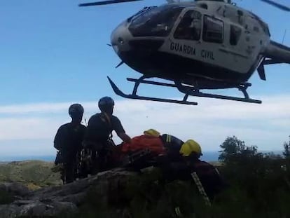 Evacuación del cadáver del piloto del helicóptero accidentado en Casares. Efectivos del Consorcio de Bomberos introducen el cuerpo en el helicóptero de la Guardia Civil.