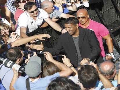 El actor Denzel Washington saluda hoy viernes a sus fans.