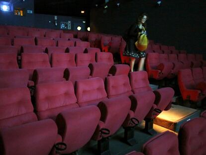 Una espectadora abandona una vacía sala de un cine madrileño.