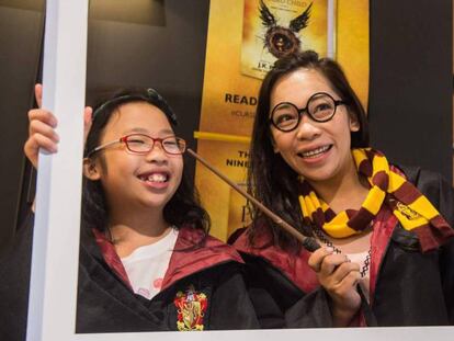 Una madre y su hija posan en una librería de Hong Kong. (FOTO: ANTHONY WALLACE / AFP)