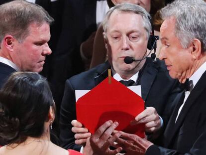 FOTO: Brian Cullinan, a la izquierda y con cara seria, auditor de PwC, habla con Warren Beatty en el escenario. / VÍDEO: Entrega equivocada del Oscar a la mejor película