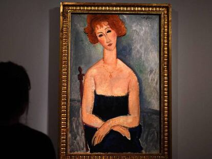 Una mujer mira 'Mujer pelirroja', de Amedeo Modigliani, en la muestra de Alicia Koplowitz en París.