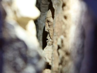 Detalle de una de las figuras en piedra ocultas tras la pared de un granero.