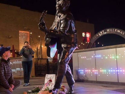 Pie de Foto: Brad Pierce enciende una vela ante la estatua de Chuck Berry en University City, en EE UU.